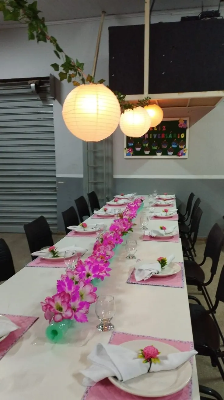 Mesa longa decorada com flores rosas para encontro