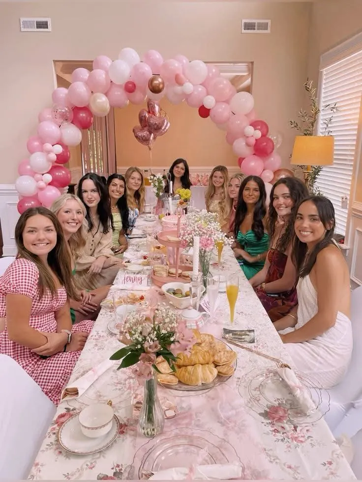 Encontro de mulheres com arco de balões e mesa decorada